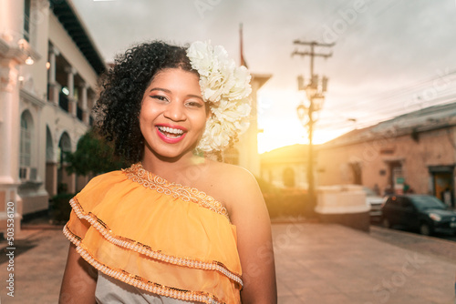 Traditional dance dancer from Nicaragua mestizo with curly hair smiling and looking at the camera at sunset wearing the typical dress of Central America photo