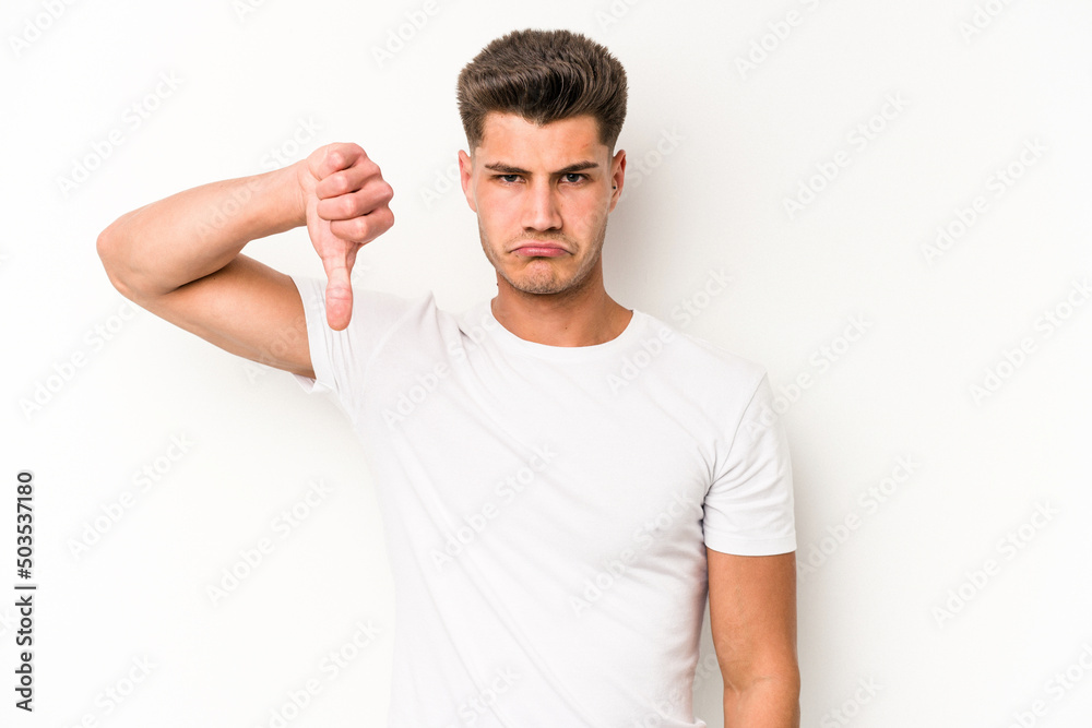 Young caucasian man isolated on white background showing a dislike gesture, thumbs down. Disagreement concept. Young caucasian man isolated on white background showing a dislike gesture, thumbs down. Disagreement concept.