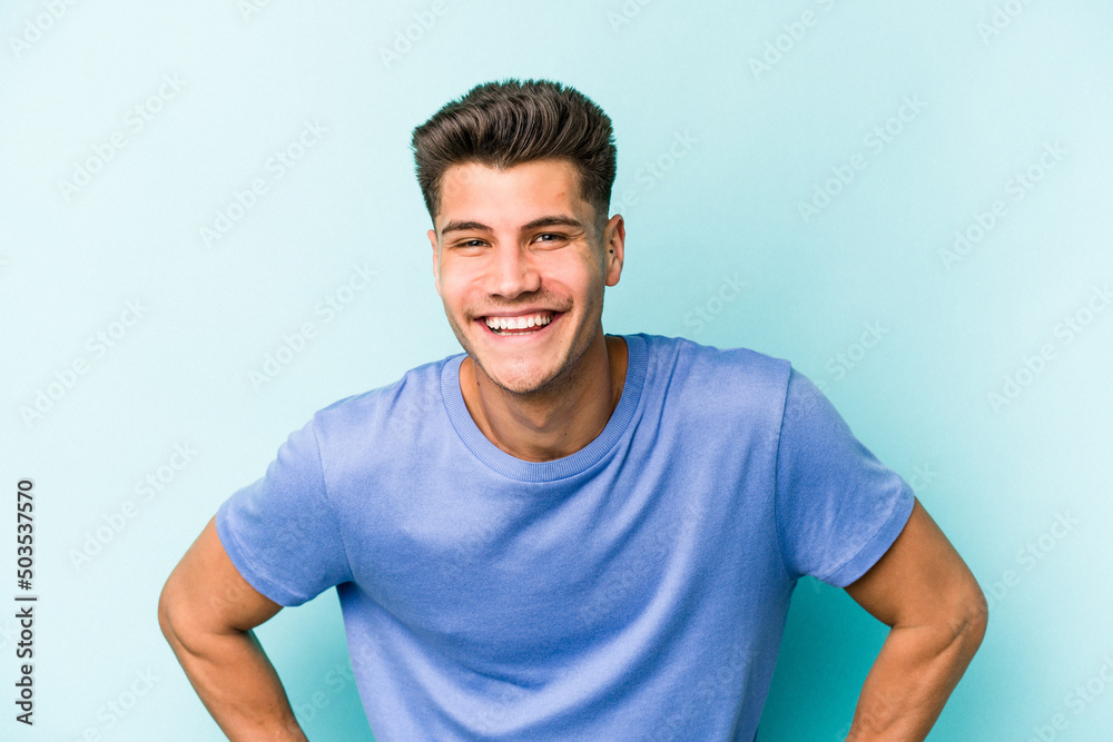 Young caucasian man isolated on blue background happy, smiling and cheerful. Young caucasian man isolated on blue background happy, smiling and cheerful.