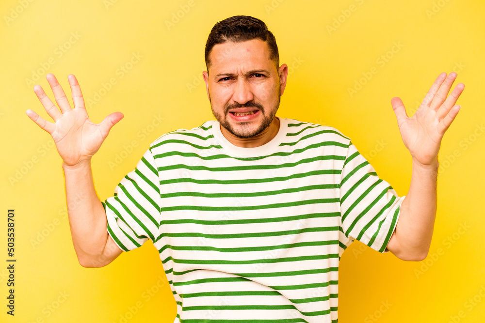 Young hispanic man isolated on yellow background screaming to the sky, looking up, frustrated. Young hispanic man isolated on yellow background screaming to the sky, looking up, frustrated.