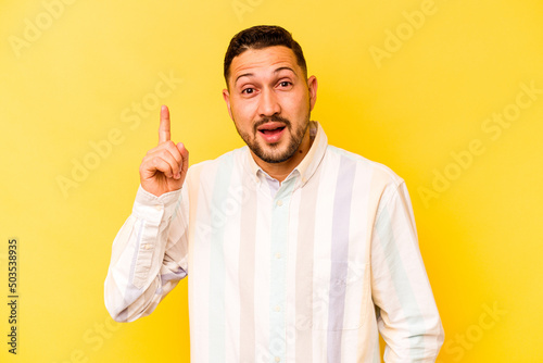 Young hispanic man isolated on yellow background having an idea, inspiration concept.