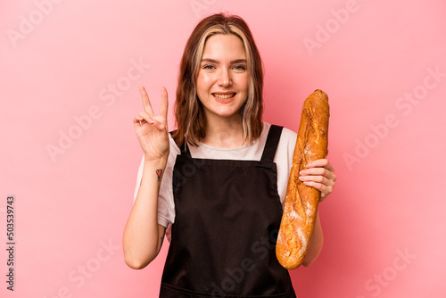 Young baker caucasian woman isolated on pink backgroundshowing number two with fingers. photo