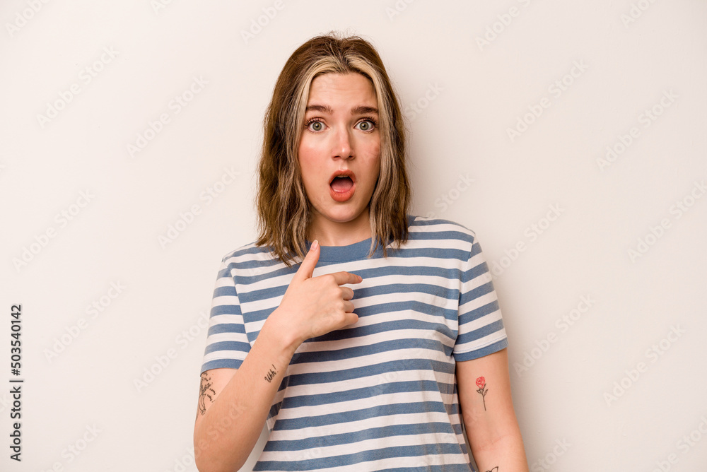 Young caucasian woman isolated on white background surprised pointing with finger, smiling broadly. Young caucasian woman isolated on white background surprised pointing with finger, smiling broadly.