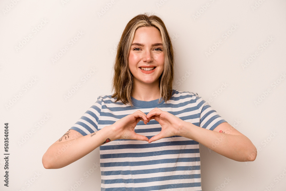 Young caucasian woman isolated on white background smiling and showing a heart shape with hands. Young caucasian woman isolated on white background smiling and showing a heart shape with hands.