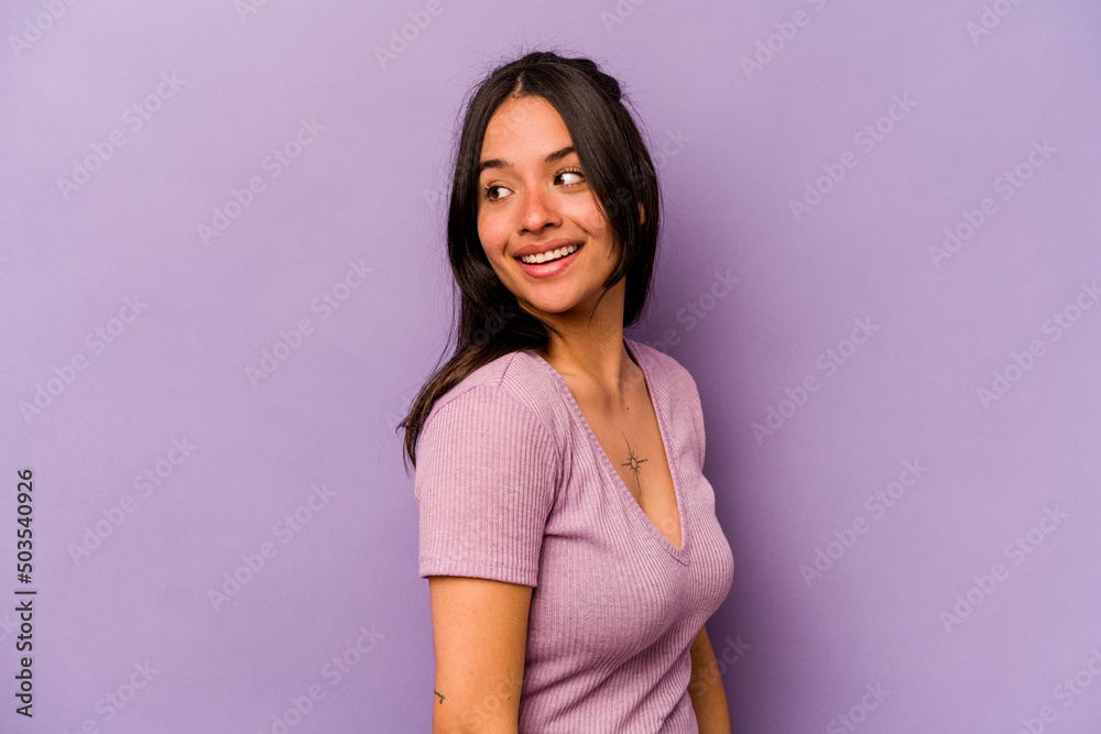 Young hispanic woman isolated on purple background looks aside smiling, cheerful and pleasant. Young hispanic woman isolated on purple background looks aside smiling, cheerful and pleasant.