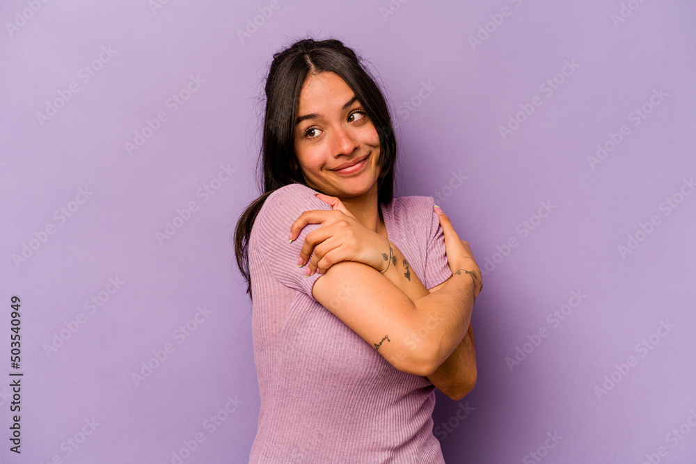 Young hispanic woman isolated on purple background hugs, smiling carefree and happy. Young hispanic woman isolated on purple background hugs, smiling carefree and happy.