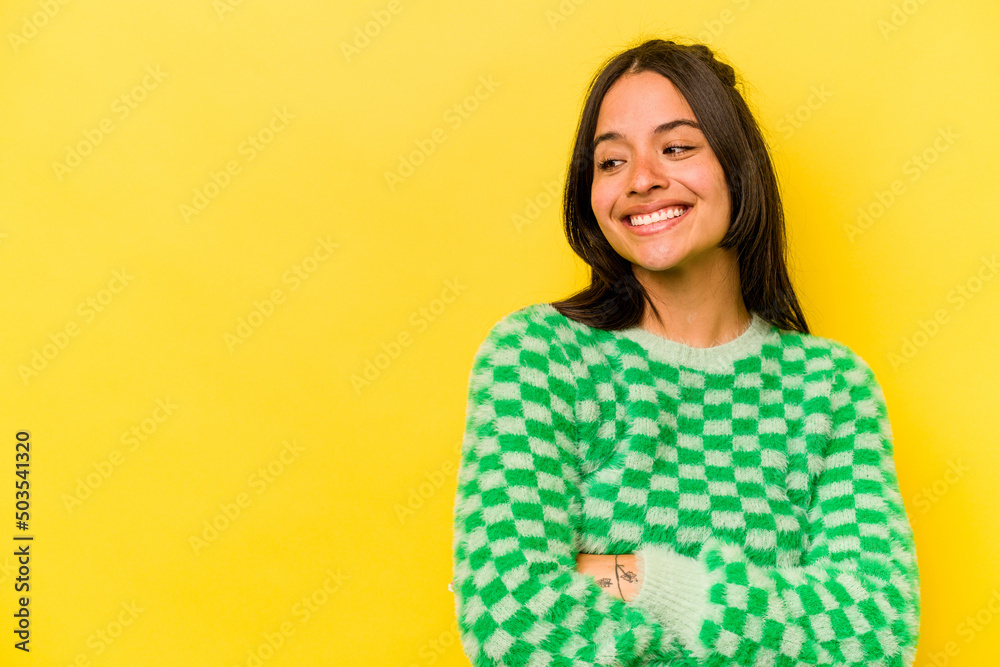 Fototapeta premium Young hispanic woman isolated on yellow background smiling confident with crossed arms.