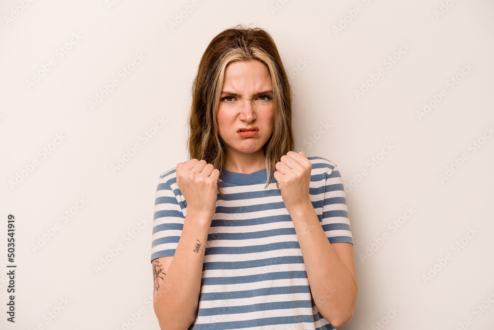 Young caucasian woman isolated on white background showing fist to camera, aggressive facial expression. Young caucasian woman isolated on white background showing fist to camera, aggressive facial expression.