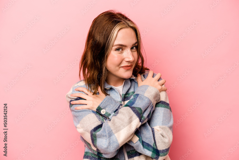 Young caucasian woman isolated on pink background hugs, smiling carefree and happy. Young caucasian woman isolated on pink background hugs, smiling carefree and happy.
