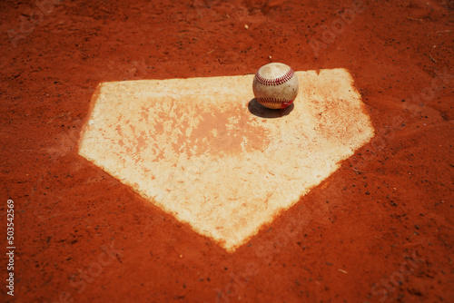 Baseball on home plate on baseball field photo