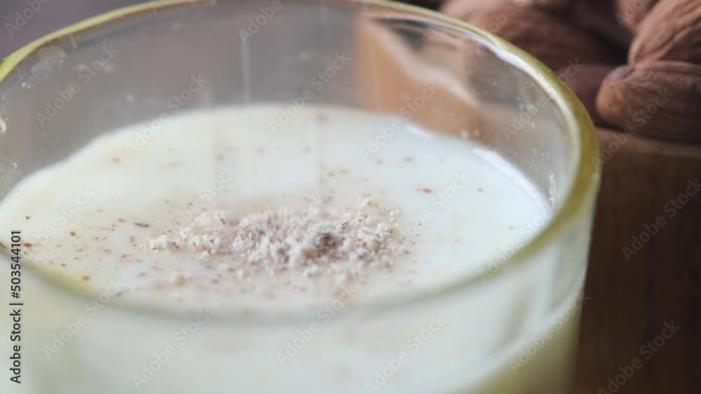 putting almond powder in a glass of milk 
