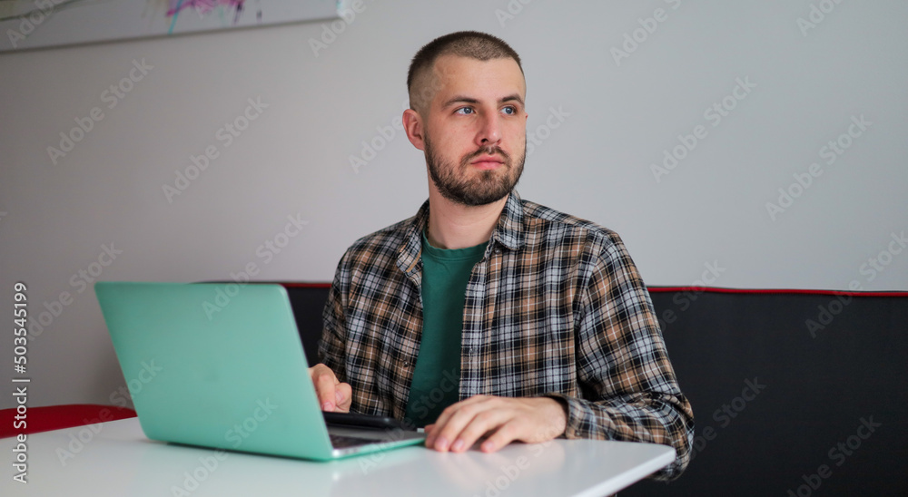 The guy in the shirt is working on the computer, working remotely. Freelancer.