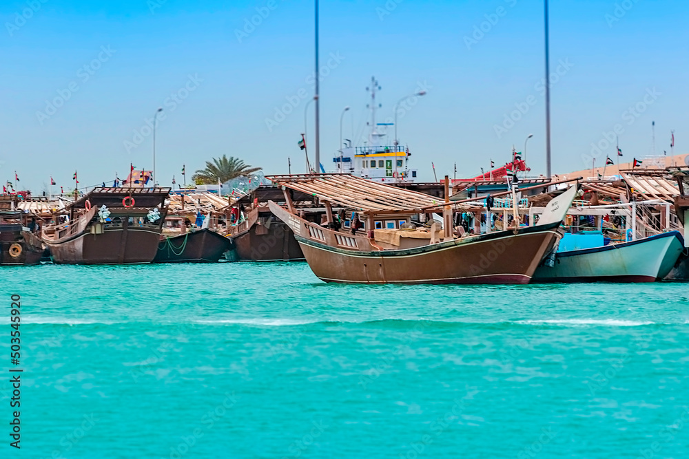 Obraz premium Traditional Dhow fishing boats mooring within Al-Mina port in Abu Dhabi, United Arab Emirates