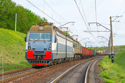 Four powerful electric locomotives pull a long heavy train to the sorting station. Spring evening lighting. © Oleksandr
