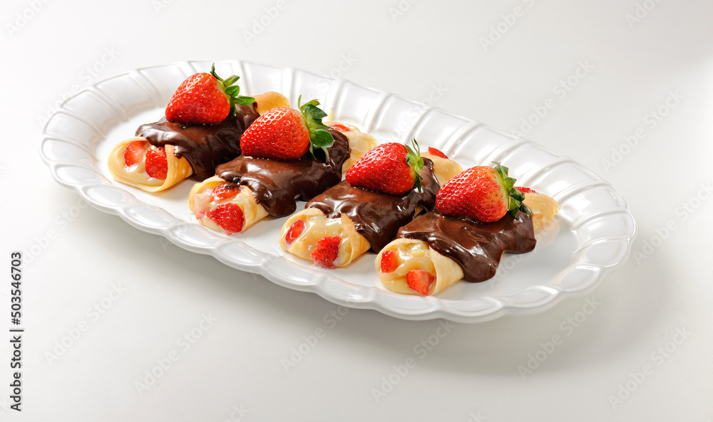 Set of four delicious crepes with strawberry and cream filling, and chocolate topping, isolated Set of four delicious crepes with strawberry and cream filling, and chocolate topping, isolated