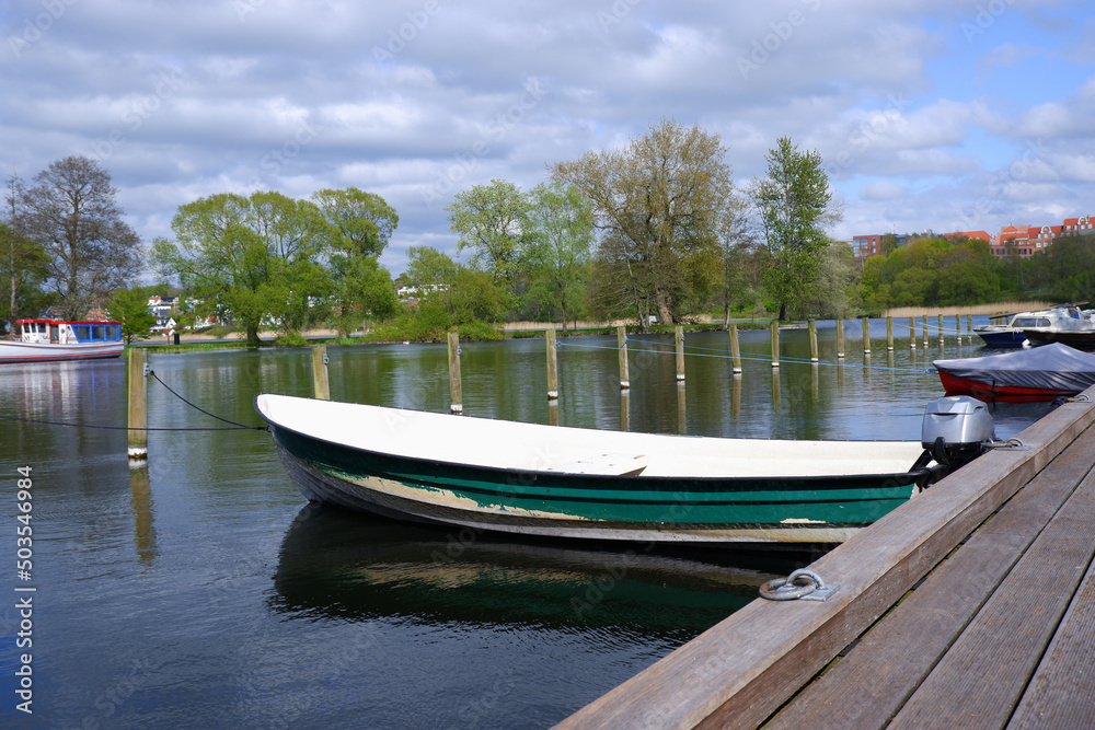 Landscape. Wooden embankment pier for boats on the lake. Place for walking in the city park.