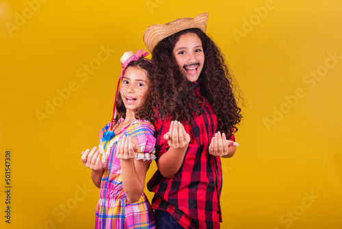 Girlfriends dressed up for Festa Junina, clothes for Festa Junina, calling with their hands, come here. Festivals in May, June and July. photo