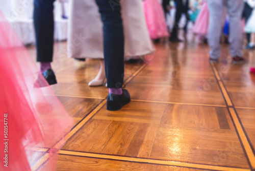Couples dance on the historical costumed ball in historical dresses, classical ballroom dancers dancing, waltz, quadrille and polonaise in palace interiors on a wooden floor, charity event © tsuguliev