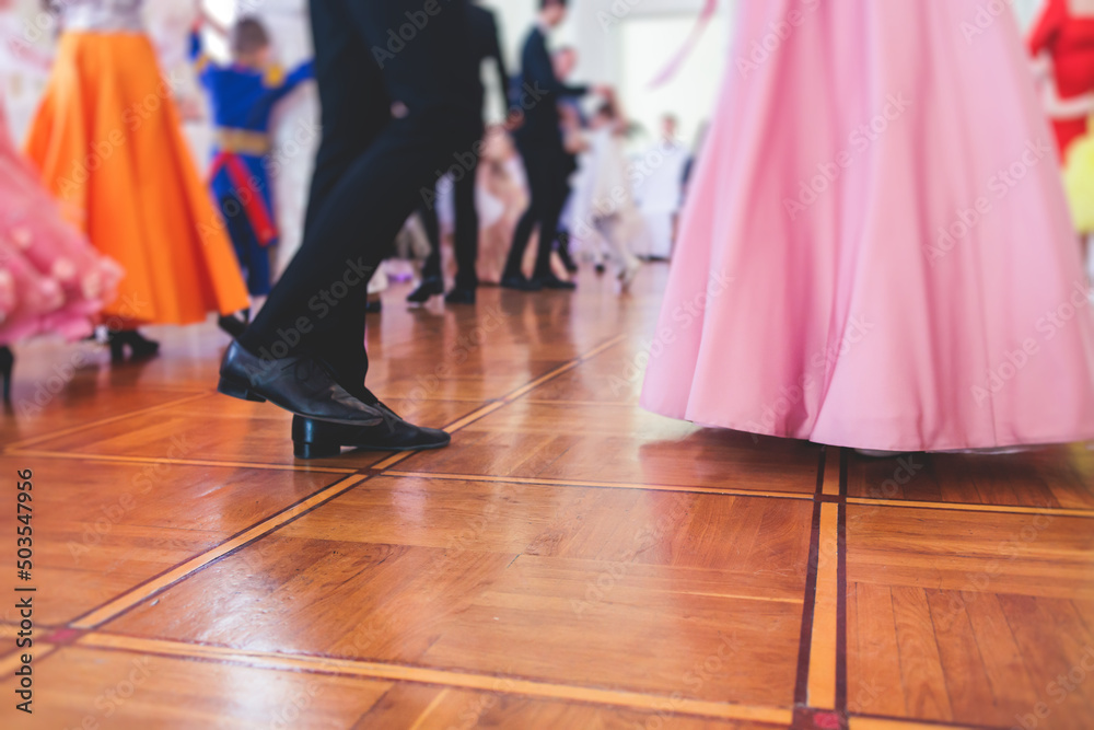 Couples dance on the historical costumed ball in historical dresses, classical ballroom dancers dancing, waltz, quadrille and polonaise in palace interiors on a wooden floor, charity event
