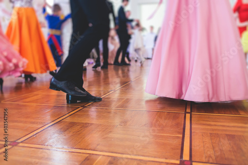 Couples dance on the historical costumed ball in historical dresses, classical ballroom dancers dancing, waltz, quadrille and polonaise in palace interiors on a wooden floor, charity event