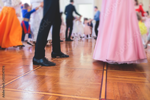 Couples dance on the historical costumed ball in historical dresses, classical ballroom dancers dancing, waltz, quadrille and polonaise in palace interiors on a wooden floor, charity event photo