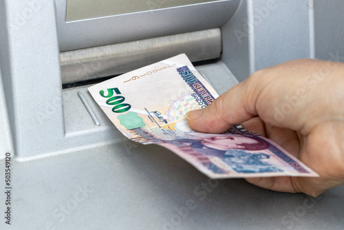 Obraz na płótnie Woman chooses 500 Lempira from ATM, Honduran currency, Highest denomination, Economic and financial concept w salonie