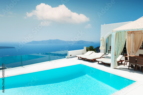 White architecture on Santorini island, Greece. Luxury swimming pool with sea view. Travel and summer vacations concept