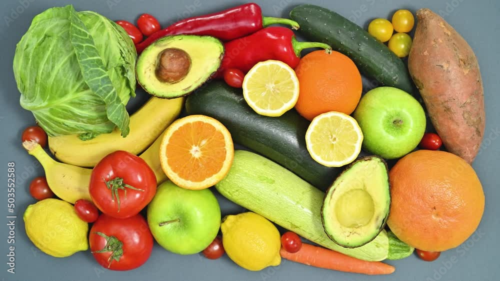 Fresh organic fruits and vegetables appear on the table with copy space paper. Flat lay stop motion. Healthy lifestyle concept Fresh organic fruits and vegetables appear on the table with copy space paper. Flat lay stop motion. Healthy lifestyle concept