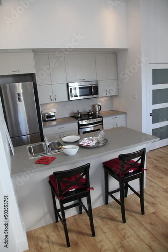 Appartement kitchen in a modern loft with stainless fridge and oven and microwave and table for breakfast photo