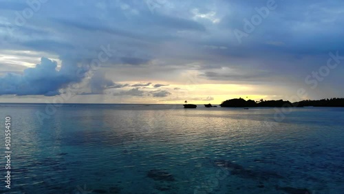 Wallpaper Mural Drone footage from a sunset in Fiji, flying towards a small island in the middle of the bay, with a tiny palm tree growing out of it. Beautiful, clear water, with the reefs visible below.  Torontodigital.ca