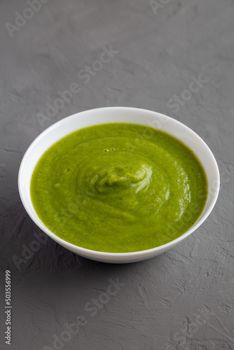 Homemade Organic Broccoli Soup on gray surface, side view.