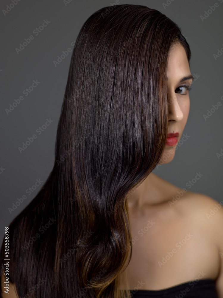 Perfect Long Wavy Hair on a Beautiful Brunette Fashion Model in Studio on a Grey Background Perfect Long Wavy Hair on a Beautiful Brunette Fashion Model in Studio on a Grey Background