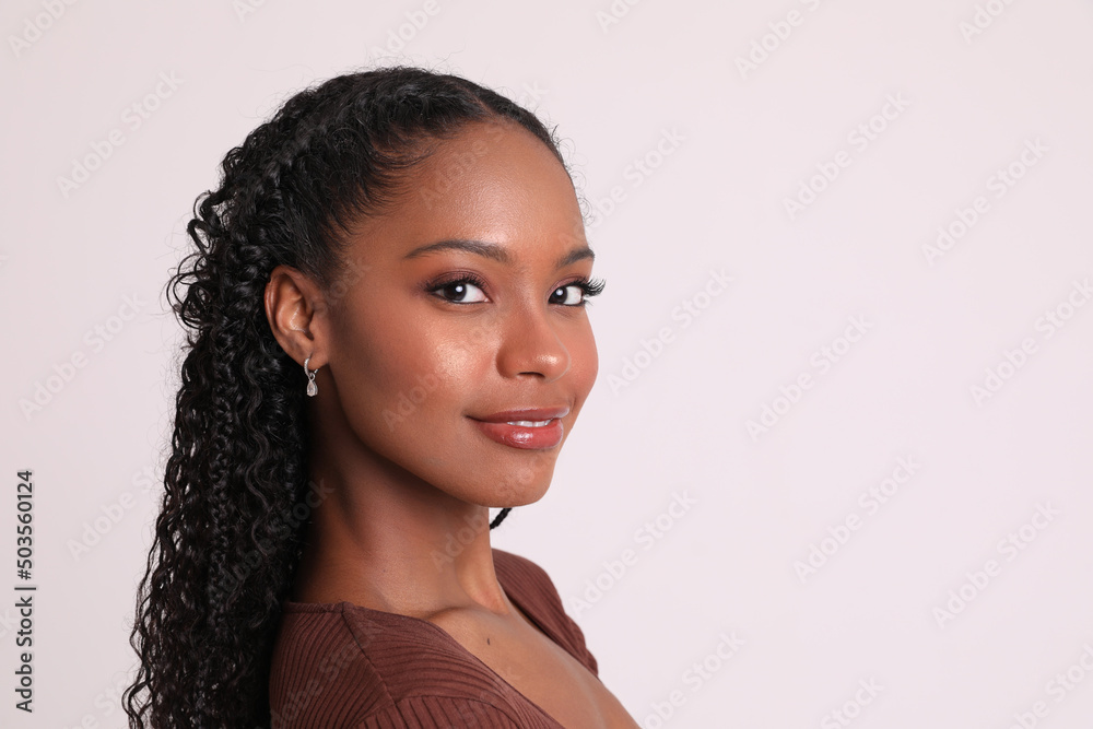 Close-up of positive dark skinned young woman looking at the camera poses indoor