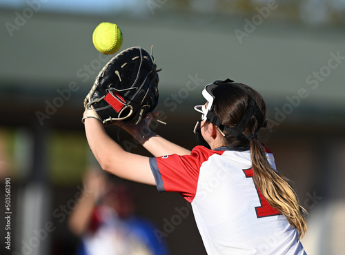 Athletic girls in action playing in a softball game photo