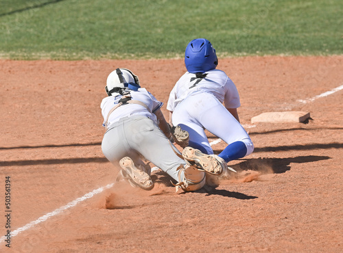 Athletic girls in action playing in a softball game