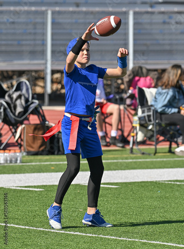 Young boy throwing and running with the ball during a flag football game