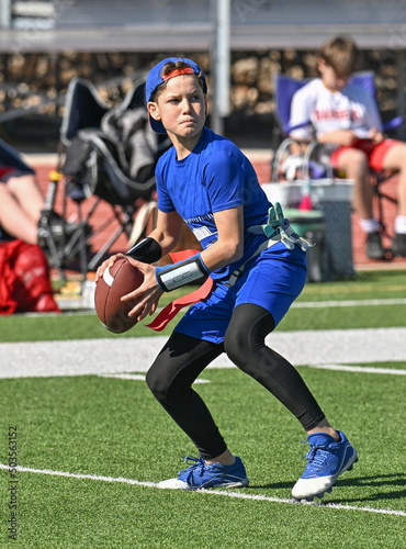 Young boy throwing and running with the ball during a flag football game