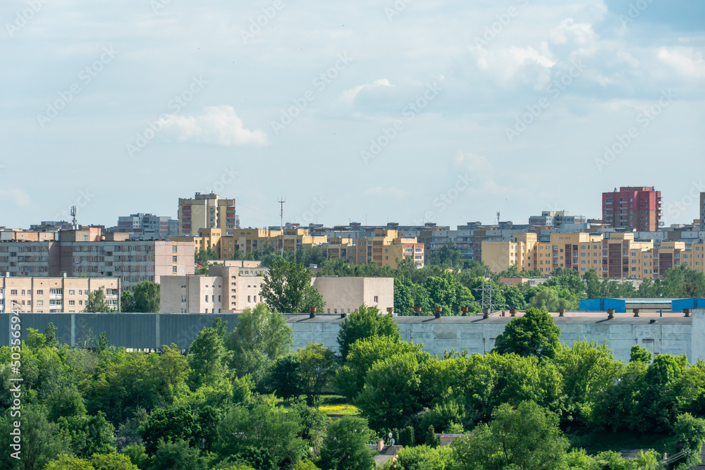 Top view of the sleeping area of a big city. Autumn city landscape. Green spaces next to high-rise modern buildings.