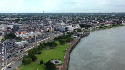 Aerial drone flight over the river near a beautiful downtown, urban city.  Blue skies with some big, puffy white clouds.  