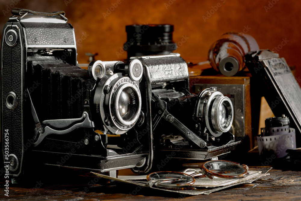 An old camera in a composition on an old background, on a table An old camera in a composition on an old background, on a table