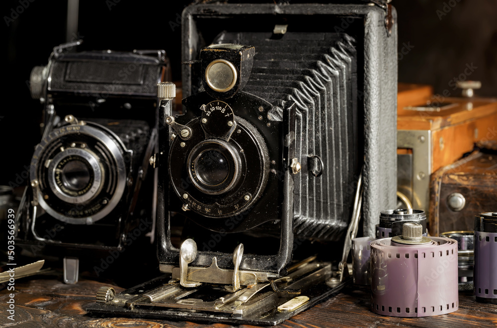 An old camera in a composition on an old background, on a table