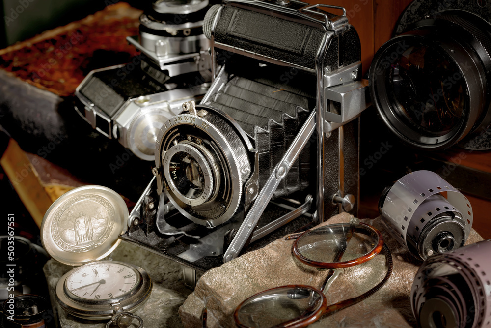 An old camera in a composition on an old background, on a table