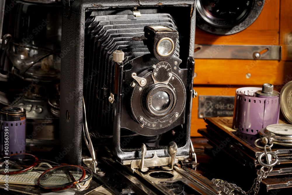 An old camera in a composition on an old background, on a table An old camera in a composition on an old background, on a table