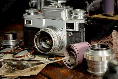 An old camera in a composition on an old background, on a table