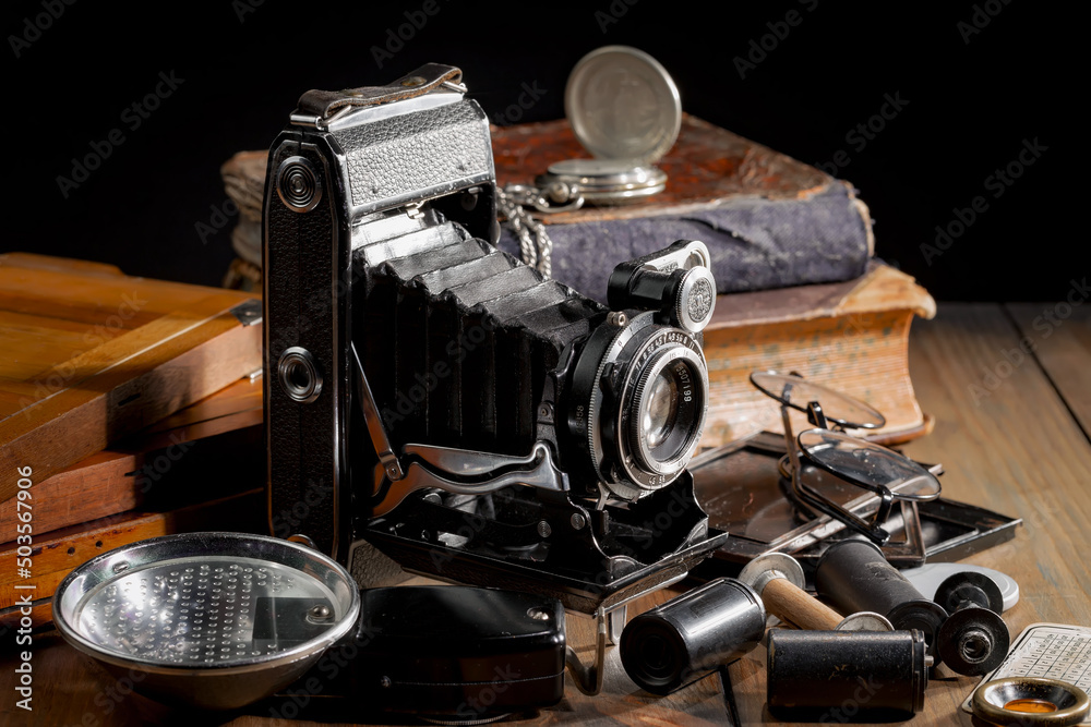 An old camera in a composition on an old background, on a table