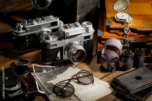 An old camera in a composition on an old background, on a table