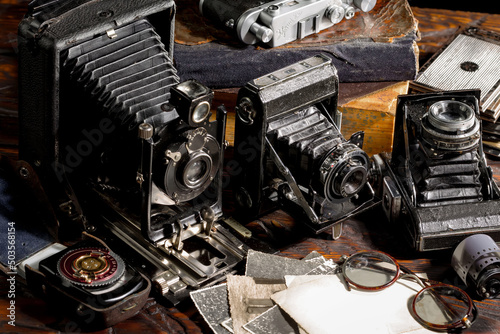 Old vintage photo cameras on an old background. © vizafoto