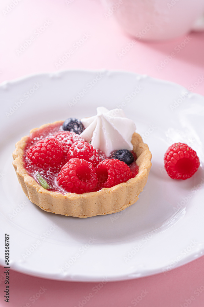 Tartlet with fresh berries and cream for pink background in hard light Tartlet with fresh berries and cream for pink background in hard light