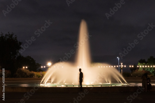 silhouette of a man at a fountain at night