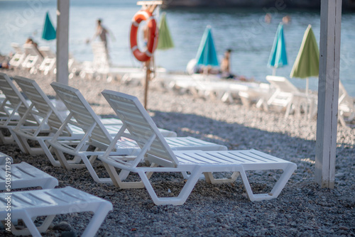 white sun loungers and an umbrella on a deserted beach. The perfect vacation concept.